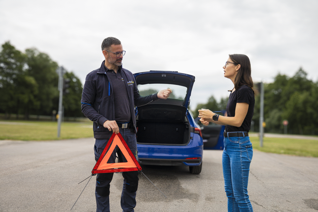 instruktor vysvětluje studentovi autoškoly použití výstražného trojúhelníku